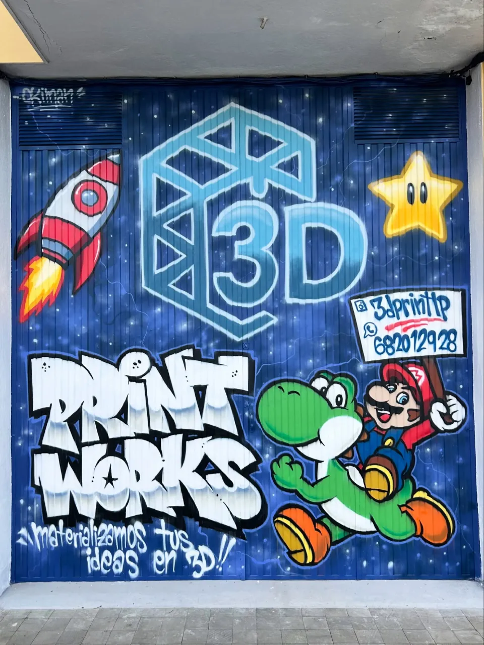 Portón de un negocio de impresión 3D pintado con su logotipo y personajes de videojuego